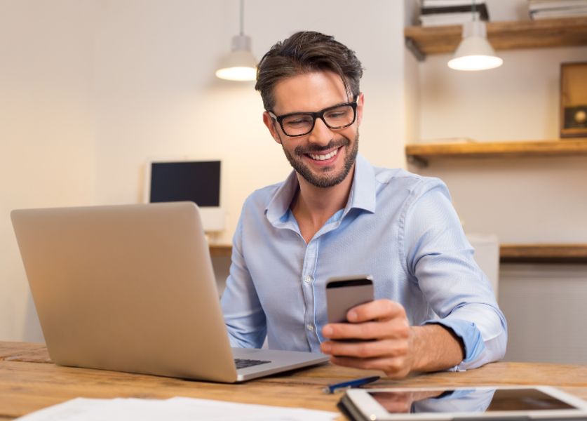 uomo guarda il computer sorridendo